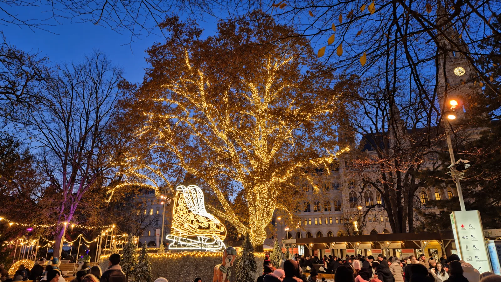Illuminierte Bäume über einem Weihnachtsmarkt